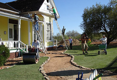 six men working on the front sod lawn of a home